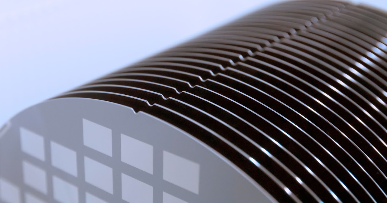 Close-up of thin semiconductor wafers stacked in a fan formation, illustrating the precision required in temporary bonding applications